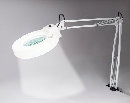 A white magnifying glass lamp mounted to the table top - Yihua YH298 115 mm 5D.