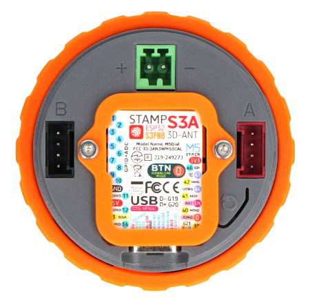 The M5Dial smart dial lies upside down on a white background.